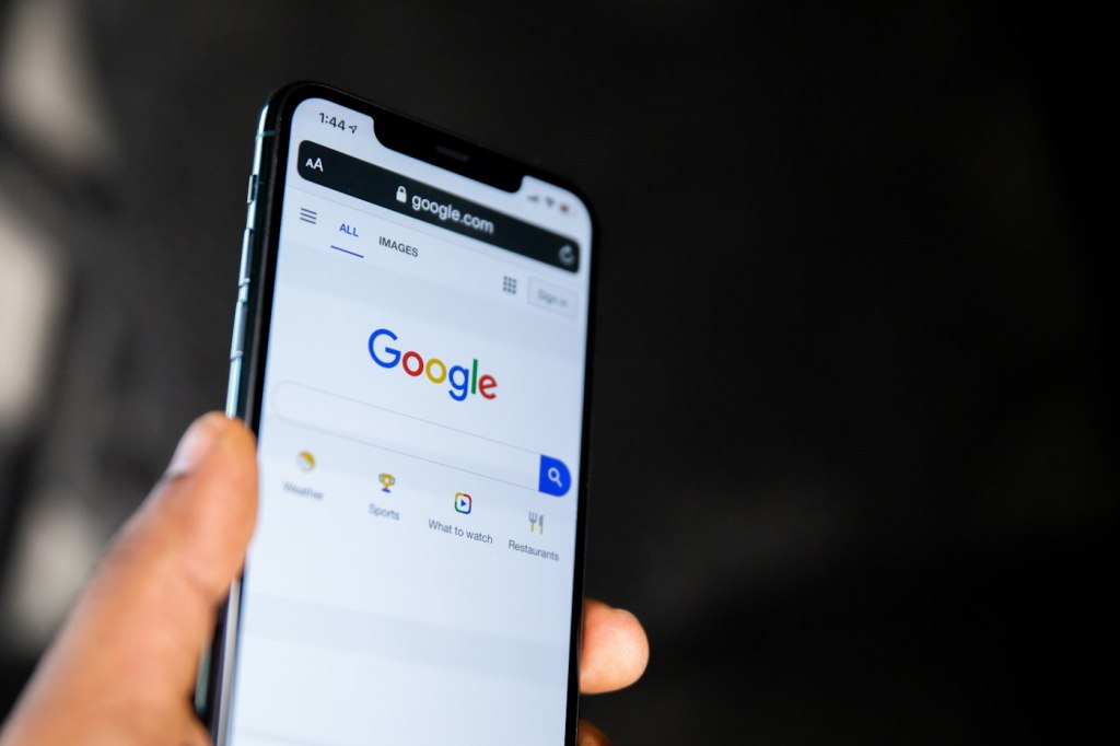Mano con un móvil abierto en el buscador de Google