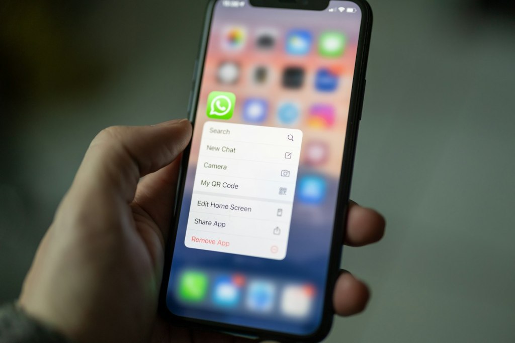 Mano sosteniendo un móvil con WhatsApp